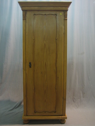 A Continental pine cupboard with moulded cornice, the interior fitted shelves enclosed by a panelled door 28"