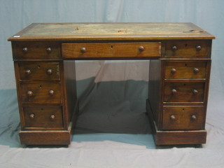 An oak kneehole pedestal desk with inset tooled leather writing surface above 1 long and 6 short drawers 46"