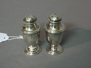 A pair of Victorian silver pepperettes raised on circular spreading feet, Sheffield 1896 and 1898, 2 ozs