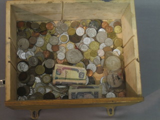 A wooden box containing various coins etc