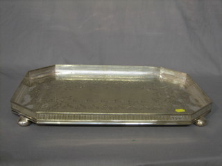 A lozenge shaped silver plated galleried tea tray, raised on bun feet 20"