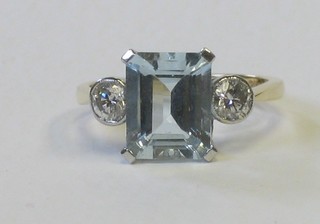 A lady's 18ct yellow gold dress ring set a square cut aquamarine supported by circular cut diamonds