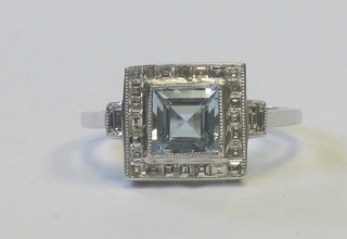 A lady's 18ct white gold dress ring set a square cut aquamarine supported by diamonds