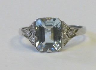 A lady's 18ct white gold dress ring set a rectangular cut aquamarine and 6 diamonds to the shoulders