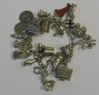A silver curb link charm bracelet hung approx. 22 charms