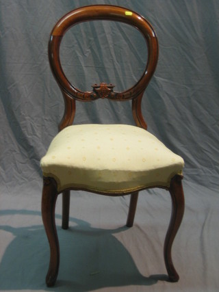 A Victorian mahogany balloon back dining chair, the seat of serpentine outline, with carved mid rail, raised on French cabriole supports