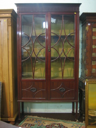 An Edwardian Chippendale style mahogany display cabinet with dentil cornice, the interior fitted adjustable shelves enclosed by an astragal glazed panelled door, raised on square tapering supports ending in spade feet 39"