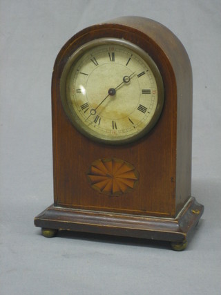 A bedroom timepiece with paper dial and Roman numerals and contained in an arch shaped mahogany case