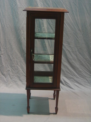 An Edwardian square pedestal glazed display cabinet, fitted shelves enclosed by a panelled door and raised on square supports ending in spade feet 14"