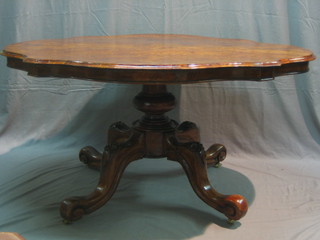 A Victorian figured walnut oval Loo table of serpentine outline raised on a carved column and tripod base 57" (no bolts)