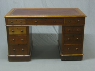 A Victorian honey oak kneehole pedestal desk with inset leather writing surface, above 1 long and 8 short drawers 49"