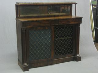 A Regency rosewood chiffonier, the raised back with brass three-quarter gallery with mirror beneath, the base fitted 2 drawers above a cupboard enclosed by panelled doors, raised on a platform base 49"