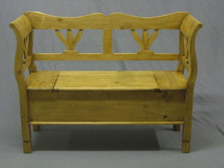 A stripped and polished pine settle, the seat with hinged lid 48"