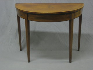A Georgian mahogany demi-lune card table with satinwood inlay, raised on square tapering supports by Gillows