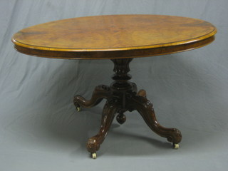 A Victorian figured walnut oval snap top Loo table, raised on pillar and tripod supports 53"