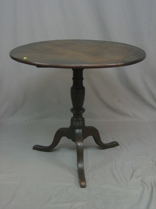A 19th Century circular oak snap top tea table, raised on column and tripod supports 35"