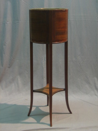 A circular inlaid mahogany jardiniere stand complete with brass liner, raised on splayed supports 12"
