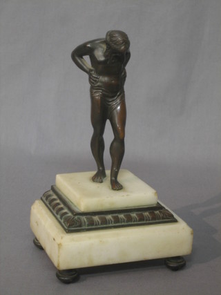 A bronze figure of a classical standing man, raised on a white marble base 8"