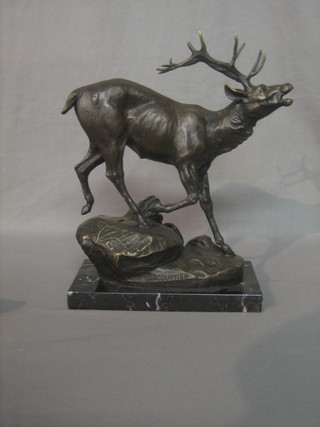 A reproduction bronze figure of a standing stag, raised on a rocky outcrop, raised on a marble base 12"