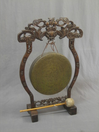 An Eastern brass dinner gong, raised on a hardwood stand