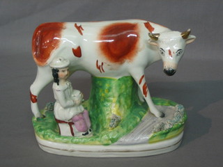 A Staffordshire figure in the form of standing cow with milk maid 6"