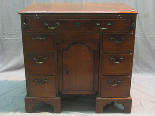 A Georgian mahogany kneehole pedestal desk/dressing table fitted a brushing slide above 1 long drawer, the base fitted a secret drawer above a cupboard flanked by 6 short drawers, raised on bracket feet, 32"