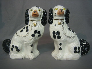 A pair of reproduction Staffordshire figures of seated black and white spaniels 10"