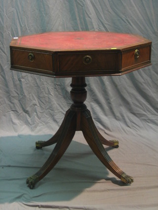 An octagonal mahogany Georgian style drum table with inset tooled leather surface, raised on pillar and club base 28"