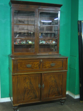 A Victorian mahogany secretaire bookcase, the upper section with moulded cornice, the interior fitted adjustable shelves enclosed by a glazed panelled door, the base fitted a secretaire drawer above a cupboard fitted 2 trays enclosed by a panelled door, raised on bun feet, 44"
