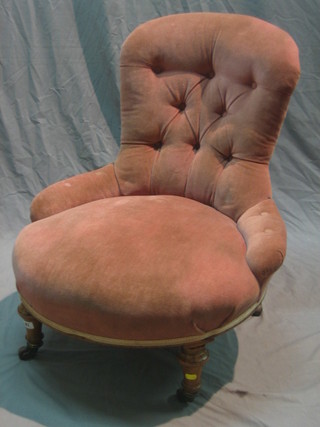 A Victorian walnut framed nursing chair upholstered in pink buttoned material