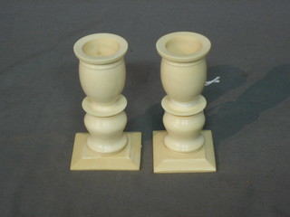 A pair of carved ivory stub shaped candlesticks, 3"