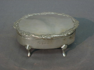 An oval silver trinket box with hinged lid, raised on bracket feet 3 1/2", Birmingham 1911