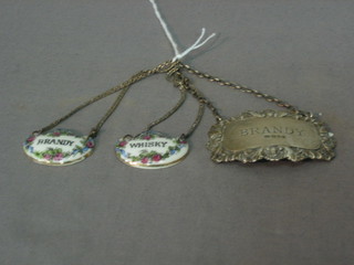 A silver decanter label marked Brandy and 2 porcelain decanter labels marked Whisky and Brandy