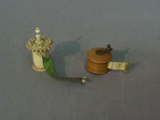 A miniature ivory cased tape measure and a wooden cased measure