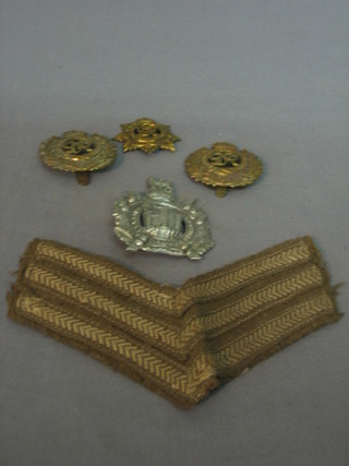 A Kings Own Scottish Borderers cap badge, 2 George V Royal Engineer's cap badges and a George V Royal Armoured Service Corps cap badge and a pair of Sergeants stripes 