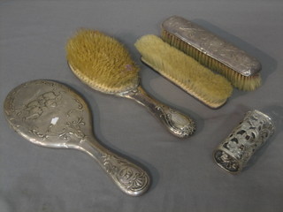 A 3 piece embossed silver backed dressing table set with hair brush, hand mirror and clothes brush, together with a silver clothes brush and a silver bottle frame
