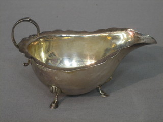 A silver sauce boat with wavy border and C scroll handle, raised on hoof feet, Birmingham 1931, 2 ozs
