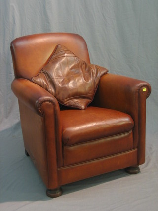 A mahogany framed leather armchair upholstered in brown leather