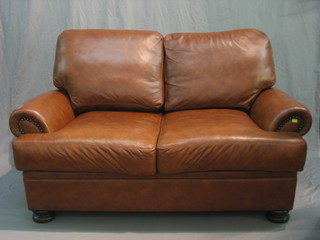 A modern 2 seat settee upholstered in brown leather 59"