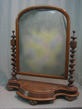 A Victorian arch plate dressing table mirror contained in a mahogany frame with spiral turned columns to the side, the base of serpentine outline fitted a drawer 27"