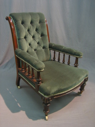 A Victorian mahogany show frame open arm chair with turned decoration, the seat and back upholstered in green buttoned material
