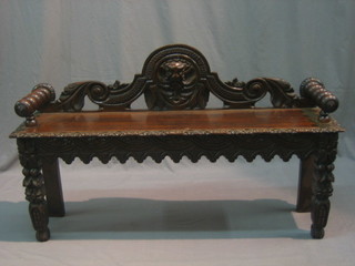 A Victorian carved oak hall bench with pierced back, raised on carved supports 50"
