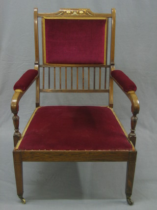 A Victorian inlaid rosewood bar back open arm chair upholstered in red