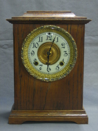 A Victorian American Ansonia 8 day striking mantel clock with porcelain dial and Arabic numerals contained in an oak case