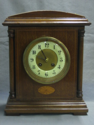 A French 8 day striking mantel clock with porcelain dial and Arabic numerals contained in an inlaid mahogany case