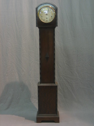 A 1930's chiming Granddaughter clock with silver dial and Arabic numerals contained in an oak case with spiral turned decoration to the side 54"