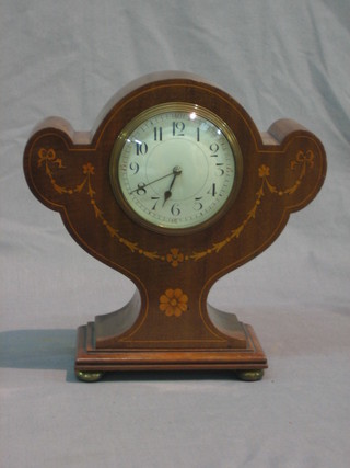 An Edwardian 8 day mantel clock with enamelled dial and Arabic numerals, contained in a shaped inlaid mahogany case