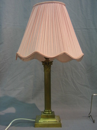A gilt metal reeded electric table lamp in the form of a reeded column with Corinthian capital, raised on a square stepped base 12"