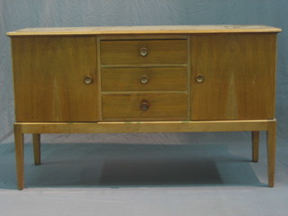 A Gordon Russell mahogany sideboard fitted 3 long drawers flanked by a pair of cupboards, raised on square supports 56" 