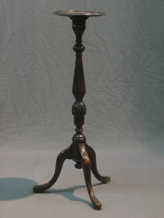 A Georgian style turned mahogany torchere raised on pillar and tripod supports